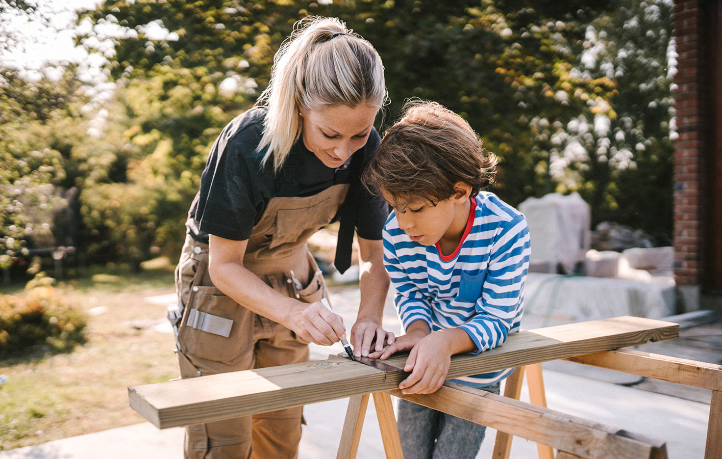 Mutter und Sohn sägen Holz - bauen gemeinsam